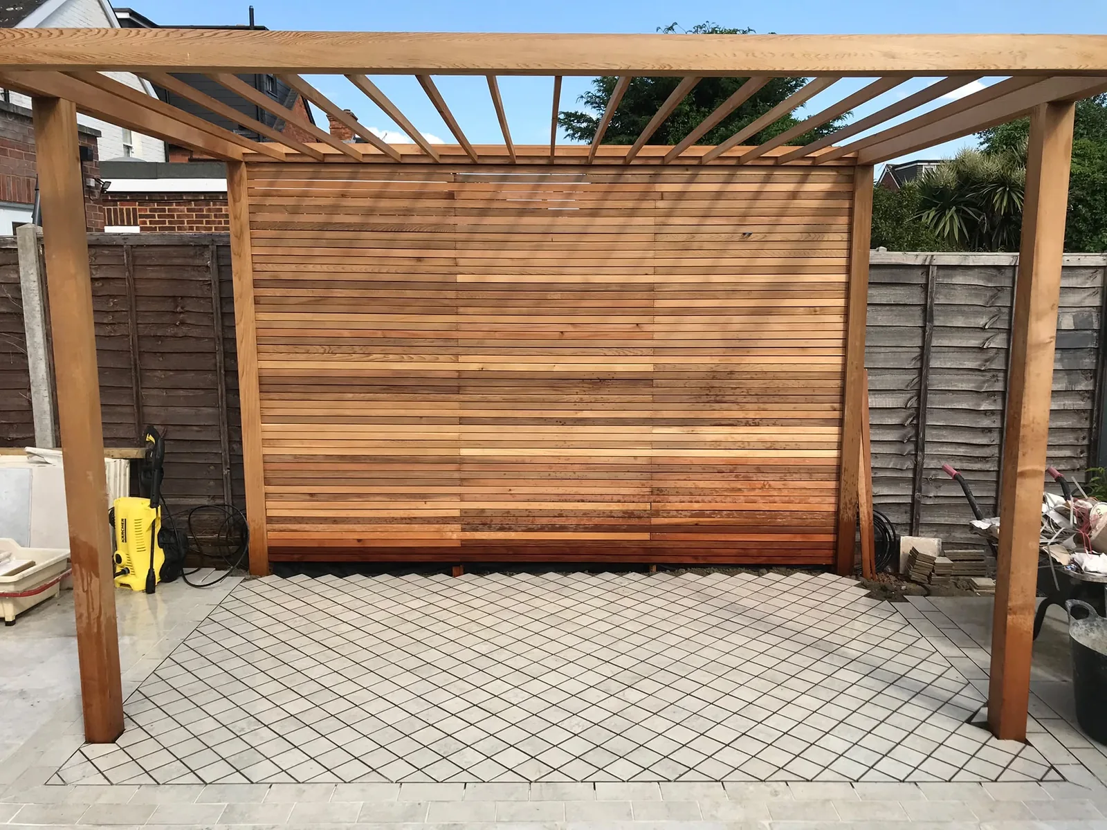 Timber garden structure beside a paved area